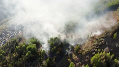 Aieral view of fire spreading on a mountain forest bank from kids starting fires Stock Footage 153053697
