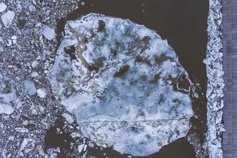 Aierial view from the top down on ice floes floating on the river. Stock Photos