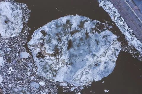 Aierial view from the top down on ice floes floating on the river. Stock Photos