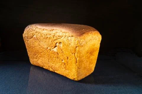 Aiming loaf of bread on turn blue table with reflection Stock Photos