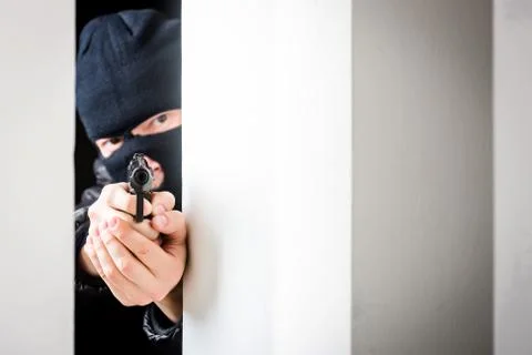 Aiming murderer with a gun Stock Photos