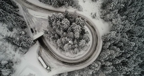 Air to air view of drone looking down on snow covered road Stock Footage 102424808