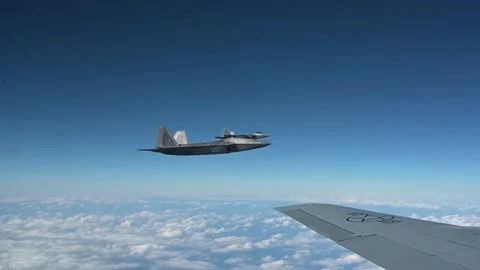 Air to air view of two U.S Air Force F-22 Raptor aircraft in flight above clouds Stock Footage 229698679
