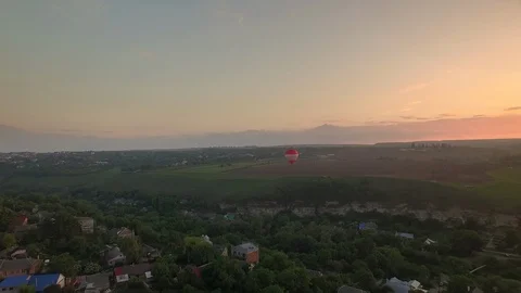 Air balloon flies over small canyon landscape and village in Kamianets-Podilskyi Stock Footage 99337850