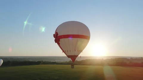 Air balloon with red bow taking off for a romantic adventure travel Stock Footage 155975455