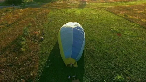Air balloons start fly from grass field at summer sunset Stock Footage 99154190