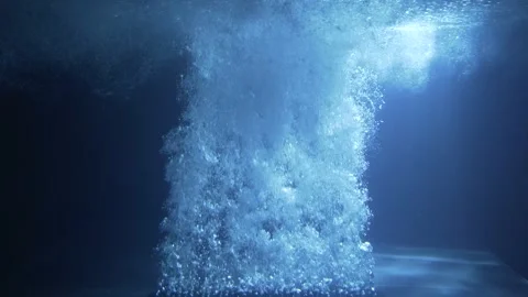 Air bubbles in blue water when illuminated by light rays. Stock Footage 247549798