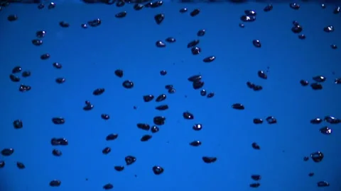 Air bubbles fall down on blue background Vídeos de archivo 87050308