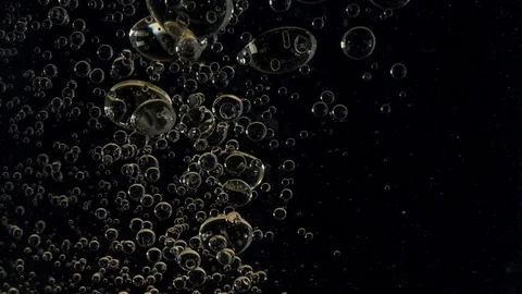 Air bubbles floating up in water on black background Stock Footage 126269461
