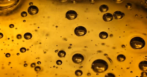 Air bubbles going up in a yellow liquid. Slow motion close up shot. Stock Footage 146602762