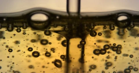 Air bubbles going up in a yellow liquid. Slow motion close up shot. Stock Footage 146603274