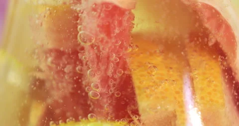 Air bubbles move along a slices of lemon in a glass of lemonade Stock Footage 145560510