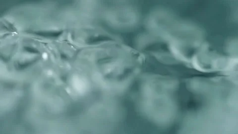 Air bubbles moving rapidly through a teal green liquid Video stock 332287249