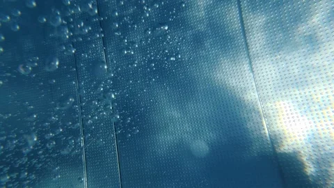 Air bubbles rising along textured swimming pool wall underwater Stock Footage 342048552