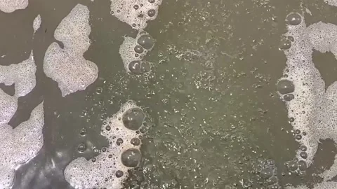 Air Bubbles Rising to the Surface of Wavy Water Stock Footage 339911904