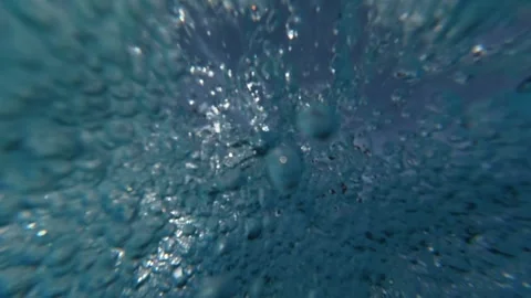 Air Bubbles Rising Through Water with Man Standing Underwater in Background Stock Footage 340899621