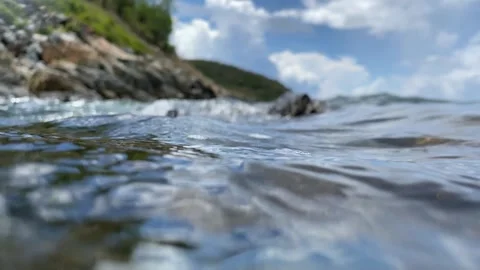 Air bubbles slowly drift upward in clear saltwater, rising toward the surface Stock Footage 313668674