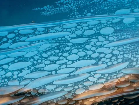 Air bubbles trapped in old deteriorated car window tint film, damaged adhes.. Stock Photos