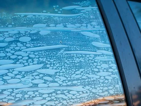Air bubbles trapped in old deteriorated car window tint film, damaged adhes.. Stock Photos