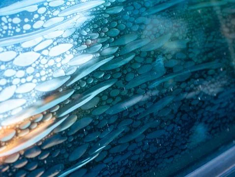Air bubbles trapped in old deteriorated car window tint film, damaged adhes.. Foto stock