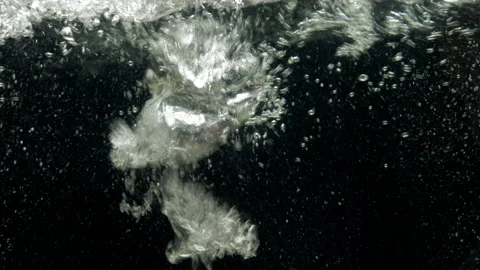 Air bubbles in water rising up to the surface on isolated black background Stock Footage 156045712