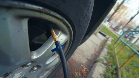 Air Compressor Hose Connected to Car Tire Valve During Inflation Process Vídeo Stock 333082673