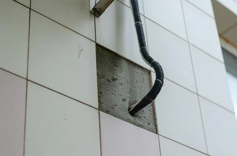 Air conditioner cable, wire, and hoses coming out of the exterior wall of the Stock Photos