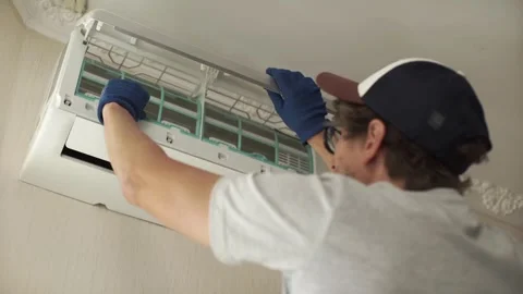 Air conditioner cleaning technician opens front cover for inspection Stock Footage 282026358
