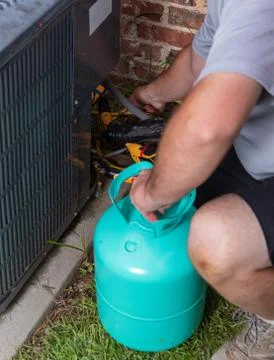 Air Conditioner maintenance with technician adding refrigerant Stock Photos
