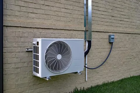 Air Conditioner mini split system next to home with brick wall Stock Photos