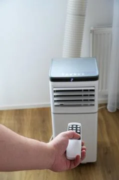 Air conditioner remote control in hand on white background. Air conditioner on Stock Photos