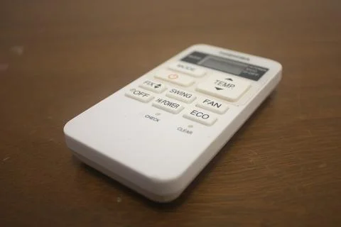 An air conditioner remote control on a table Stock Photos
