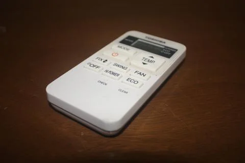 An air conditioner remote control on a table Stock Photos