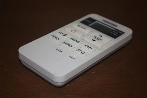 An air conditioner remote control on a table Stock Photos