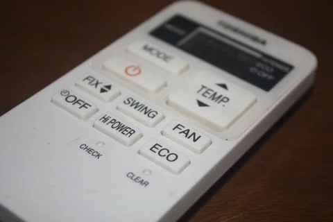 An air conditioner remote control on a table Stock Photos