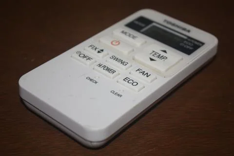 An air conditioner remote control on a table Stock Photos