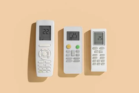 Air conditioner remote controls on beige background Stock Photos