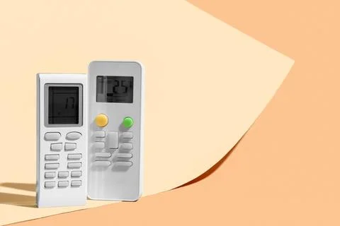 Air conditioner remote controls on beige background, closeup Stock Photos