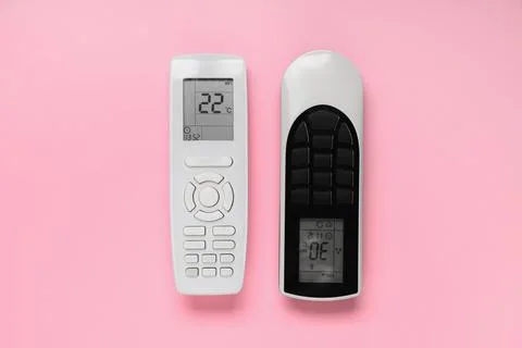 Air conditioner remote controls on pink background Stock Photos
