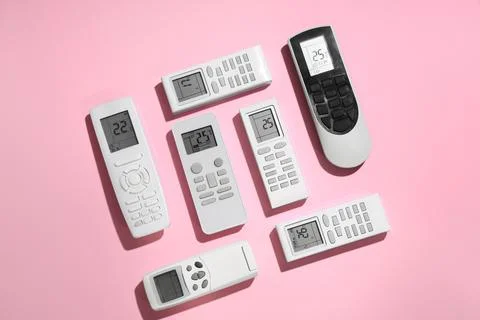 Air conditioner remote controls on pink background Stock Photos