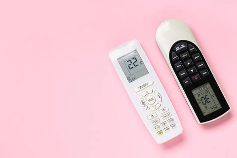 Air conditioner remote controls on pink background Stock Photos