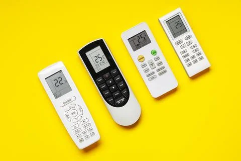 Air conditioner remote controls on yellow background Stock Photos