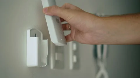 Air conditioner remote on wall. Man hand take it and use. Stock Footage 169182322