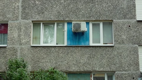 Air conditioner unit mounted on Soviet apartment facade window panel Daugavpils Stock Footage 342685484