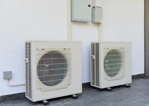 Air conditioning compressor outdoor unit installation of the building side wall Stock Photos