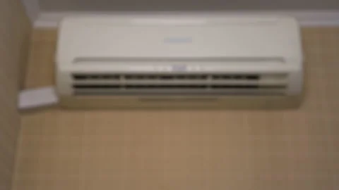 Air conditioning in the house to adjust the temperature in the room. A woman Stock Footage 132704645