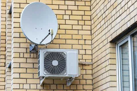 An air conditioning system installed outside on the wall of a brick building. Photos