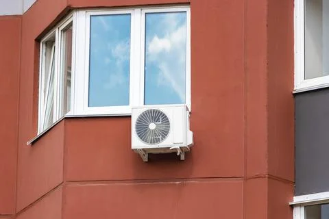 An air conditioning system installed outside on the wall of a brick building. Photos