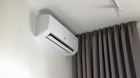 Air conditioning unit functioning silently near deep pleated fabric curtain.. Stock Footage 346155945