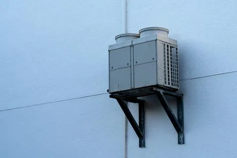 Air conditioning unit mounted on a wall for efficient cooling Stock Photos